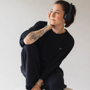 Frau mit Kopfhörer auf, die das oversized shirt love in der Farbe schwarz trägt.