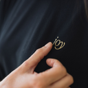 Gelber Stick von Joy in Nahaufnahme vom schwarzen oversized shirt. Ein Finger streicht sanft über den gelben Schriftzug.