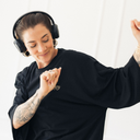 Frau die lacht und tanzt. Sie trägt das oversized shirt joy in der Farbe schwarz.
