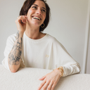 Frau die lacht. Sie trägt das oversized shirt joy in der Farbe ecru (ungefärbte Baumwolle).